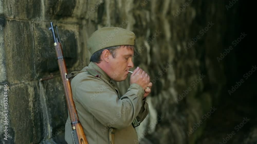 Actor dressed in military uniforms. Soldiers of the Soviet army smokes. The army of the USSR. A soldier with a rifle guarding a railway tunnel. Actor dressed in military uniforms. Soldiers of the Soviet army smokes. The army of the USSR. A soldier with a rifle guarding a railway tunnel.