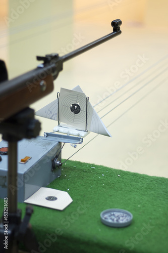 Air gun and target on counter in shooting range