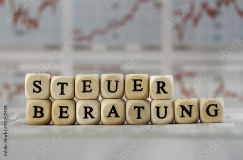 Steuerberatung mit Buchstabenwürfeln auf eine Zeitung gebaut