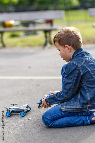 Boy plays with his drone in the park photo