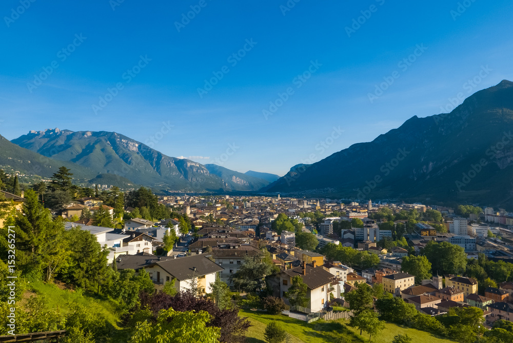 Fototapeta Sunset over the mountain town in alpine valley