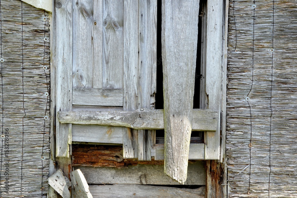 Window of an old wooden abandoned house demolishing in the wilderness
