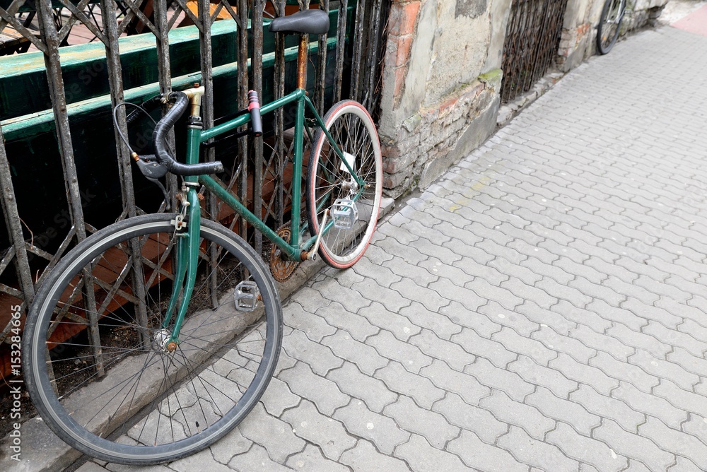 Old rusty cycling bike pinned to the fence