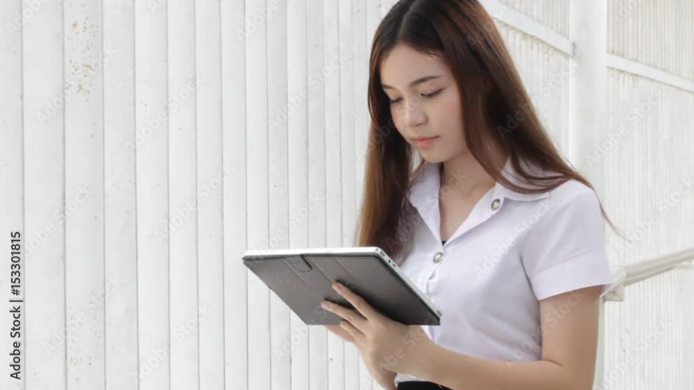 Portrait of thai adult student university uniform beautiful girl using her tablet. Portrait of thai adult student university uniform beautiful girl using her tablet.