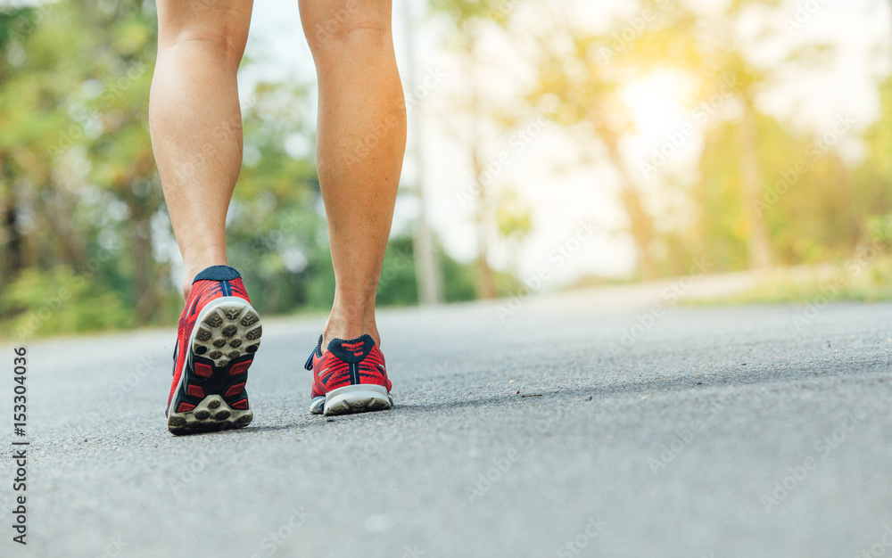 Runner feet running on road closeup on shoe Runner feet running on road closeup on shoe