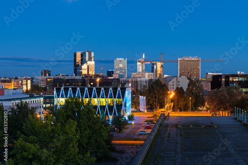 TALLINN, ESTONIA - AUGUST, 15, 2016: Aerial cityscape of modern business financial district with tall skyscraper buildings illuminated at night photo