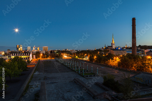 TALLINN, ESTONIA - AUGUST 15, 2016: Aerial cityscape of modern district with tall skyscraper buildings illuminated at night and old town. photo