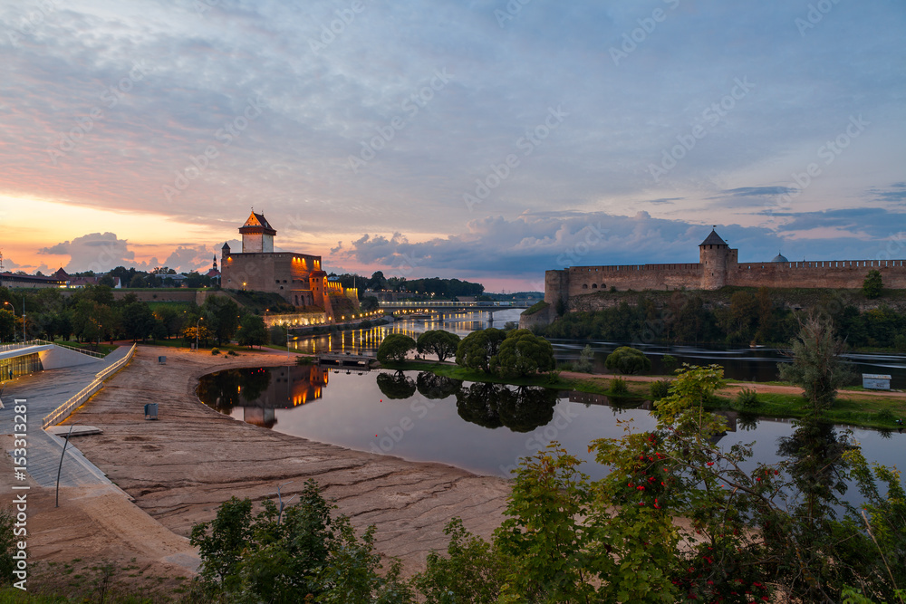 Opposition of two medieval fortresses on the river Narva at sunset, Estonia and Russia border