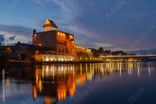 Illuminated medieval fortress on the river Narva, Estonia and Russia border. Blue hour