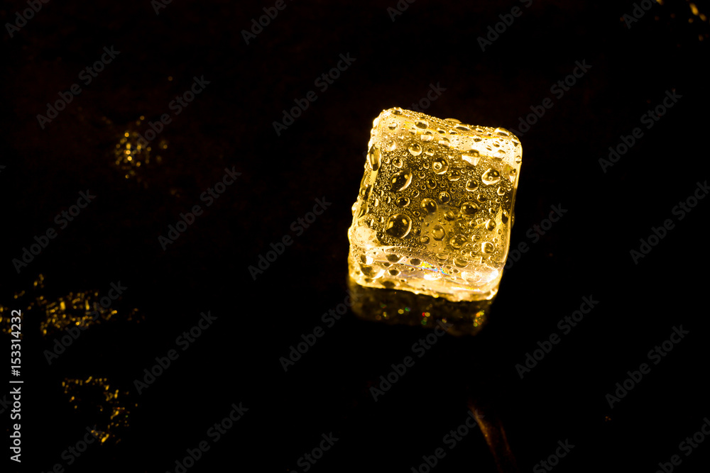 ice cubes and water drop on light golden background. ice cubes and water drop on light golden background.