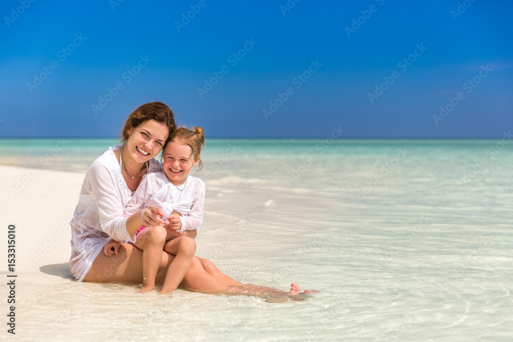 Mother and little daughter playing on sunny beach Mother and little daughter playing on sunny beach