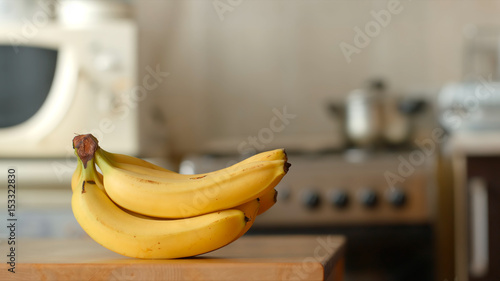 Bananas lie on a table in a kitchen