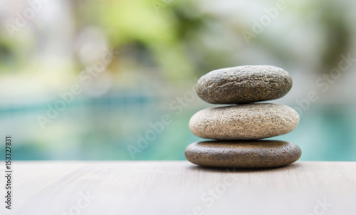 3D rendering of balancing Zen stones in water with blue sky and