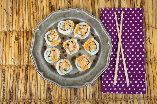 sushi pinwheels on pewter plate with chop sticks on polka dot napkin