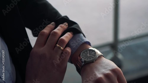 Businesswoman looks at his watch