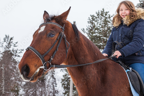 Girl teenager and big horse in a winter © keleny