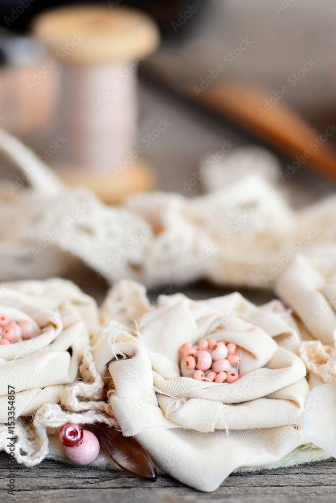 Shabby chic flowers necklace from cotton fabric, lace trims, beads and felt base on a wooden background. Summer fabric jewellery. Hand flowers necklace. Art to wear. Vertical photo. Closeup Shabby chic flowers necklace from cotton fabric, lace trims, beads and felt base on a wooden background. Summer fabric jewellery. Hand flowers necklace. Art to wear. Vertical photo. Closeup