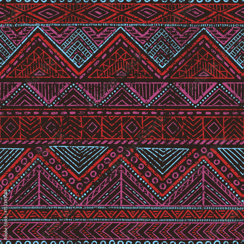 Seamless vintage pattern. Ethnic and tribal motifs. Grungy texture. Black, red, blue and purple colors.