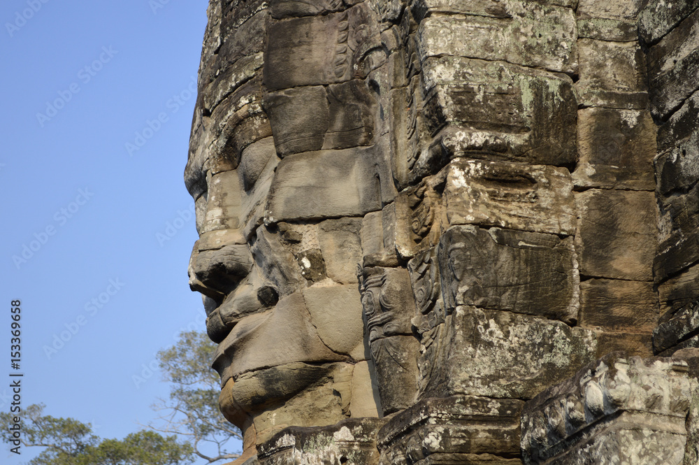 Obraz premium A stone face carved into a tower at the ancient Bayon Temple in Cambodia. Angkor Wat.