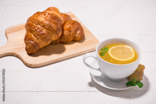 Healthy ginger tea with morning breakfast on a wooden table