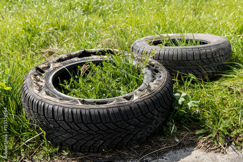 Two old damaged tires are on the road.