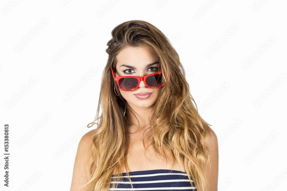 Beautiful and young blond woman in red sunglasses and blue blouse and white stripes