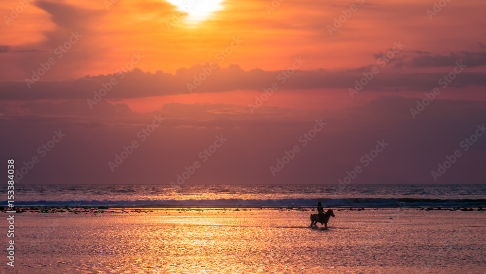 Young horse rider silhouette on a sunset beach in Gili Trawangan, Indonesia