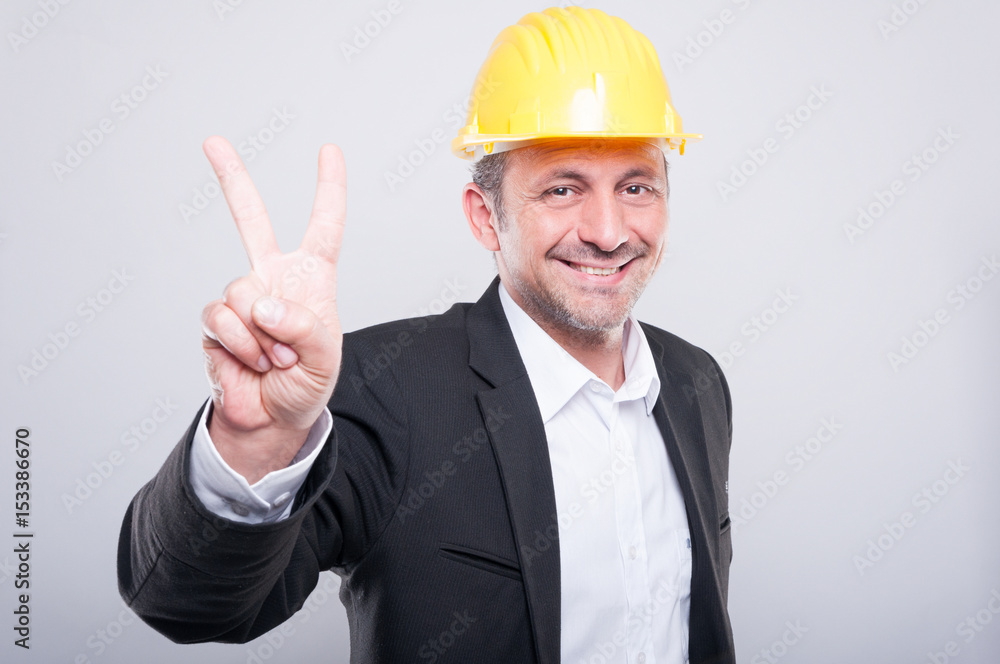 Portrait of engineer wearing hardhat showing peace Portrait of engineer wearing hardhat showing peace