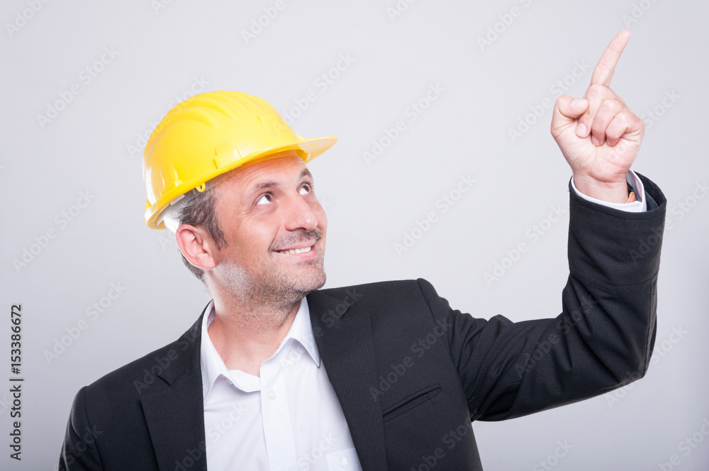 Foreman wearing hardhat pointing up