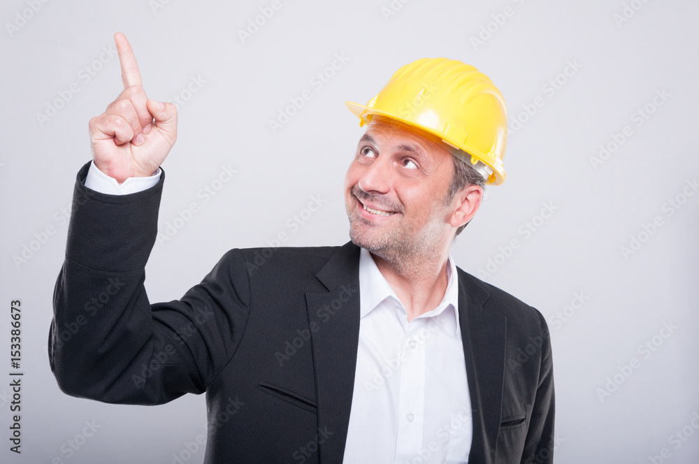 Foreman wearing hardhat pointing up