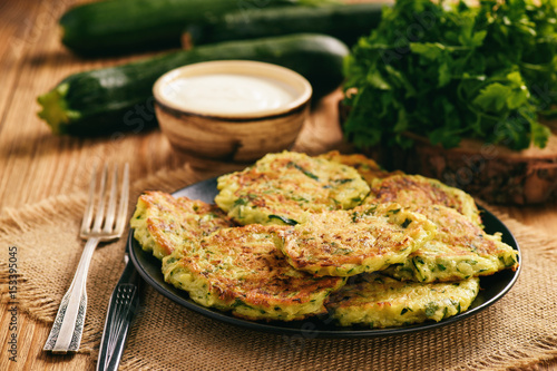 Photos Vegetarian food - zucchini fritters on wooden background.