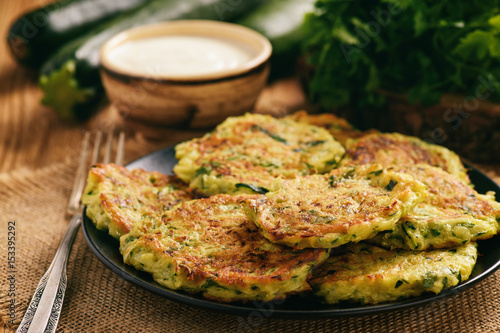 Vegetarian food - zucchini fritters on wooden background. photo
