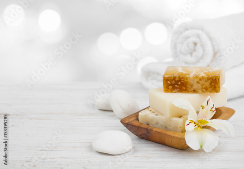 Essential spa products on wooden surface over abstract lights background