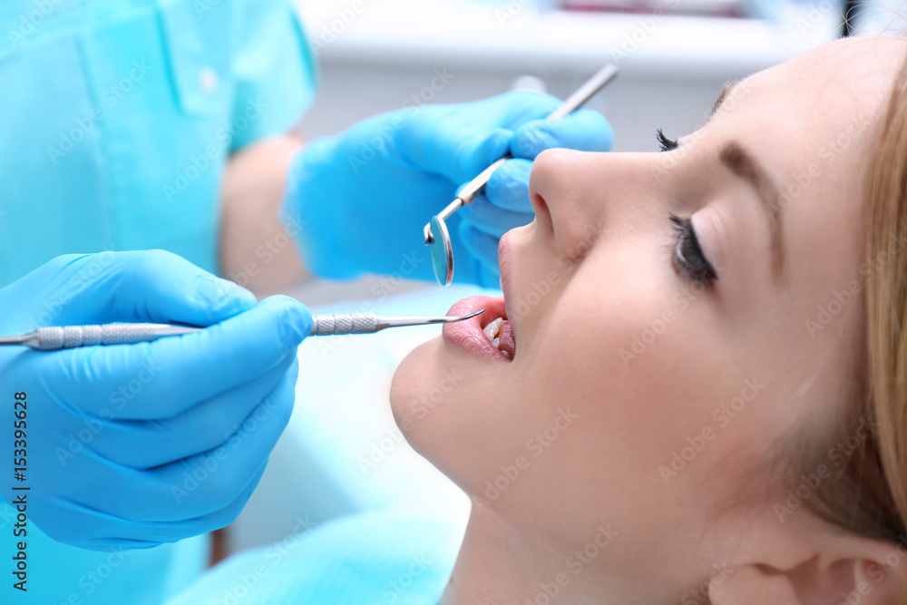 Dentist examining patient's teeth in clinic Dentist examining patient's teeth in clinic