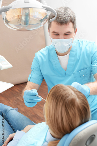 Dentist examining patient s teeth in clinic