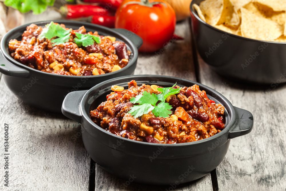 Bowls of hot chili con carne with ground beef, beans, tomatoes and corn Bowls of hot chili con carne with ground beef, beans, tomatoes and corn