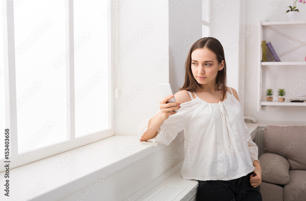 Young thoughtful woman with smartphone in hands Young thoughtful woman with smartphone in hands