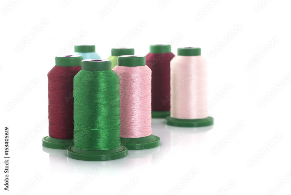 Colored threads on reels on a white background Colored threads on reels on a white background