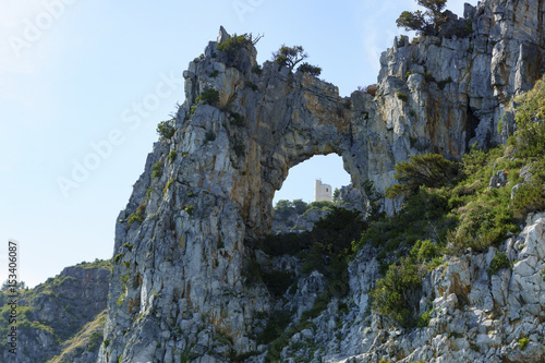 Am Kap von Palinuro: Felsenfenster, das durch Winderosien entstanden ist und dahinter die Wetterstation von Palinuro photo