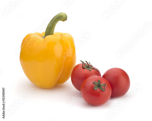 Yellow sweet pepper and red cherry tomatoes on a white background