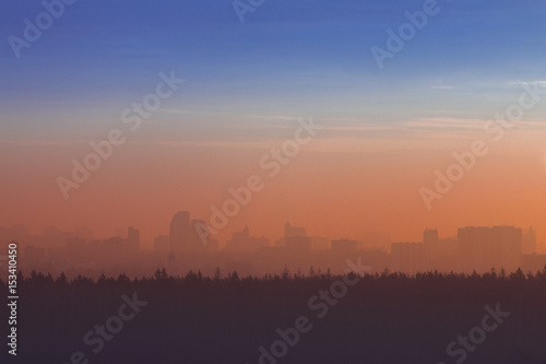 Silhouette of  city and forest at sunrise