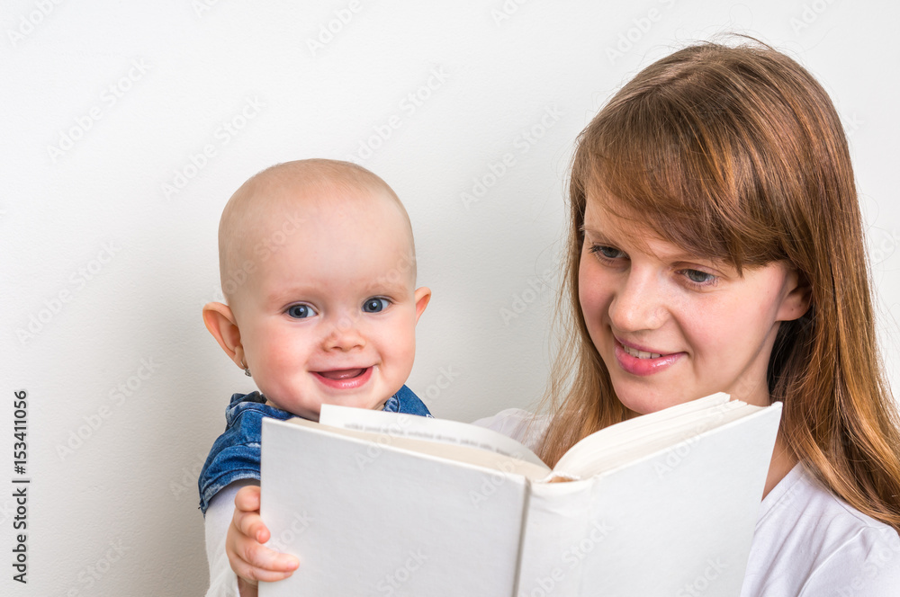 Smiling mother and her child reading a book Smiling mother and her child reading a book