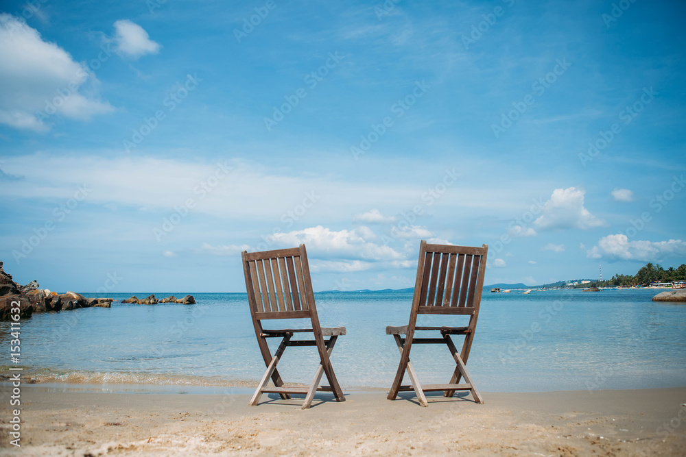 Two beach chairs on tropical shore