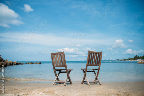 Two beach chairs on tropical shore © Olga