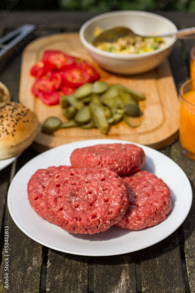 Barbecue, BBQ in the garden. Ingredients. Fresh burger with beef on wooden table.