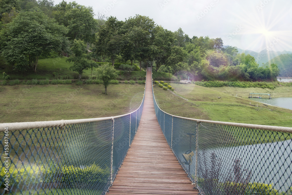 Obraz premium The rope bridge in the park directly onto the solitary island on the lake