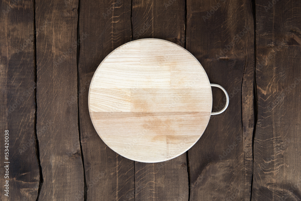 Top view of new circular wooden chopping board on wooden background Top view of new circular wooden chopping board on wooden background