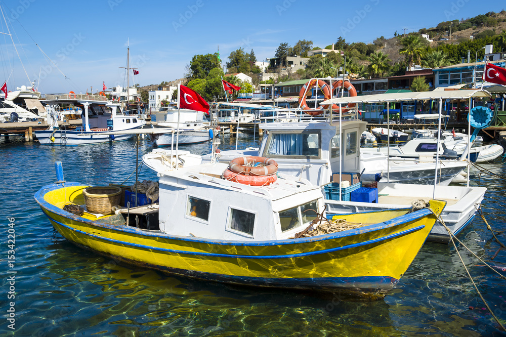 Scenic view of boats in the marina of a traditional Mediterranean fishing village in the seaside tourist village of Gumusluk, near Bodrum, Turkey