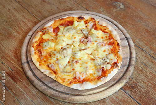 Delicious homemade pizza served on wood tray against wooden table