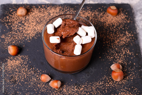 Chocolate mousse with marshmallows in portion glasses on slate cheese board photo